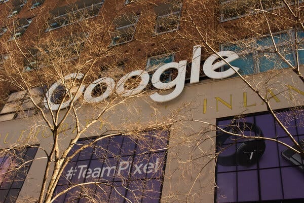 The Google logo in white letters on the company’s headquarters in New York, with a #TeamPixel sign in the window.