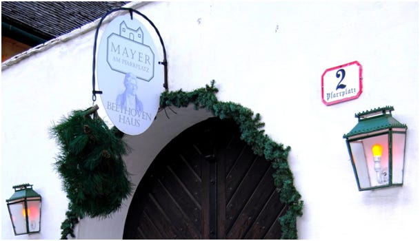 Vintner's bush and a sign commemorating Beethoven at the entrance to Mayer am Pfarrplatz.