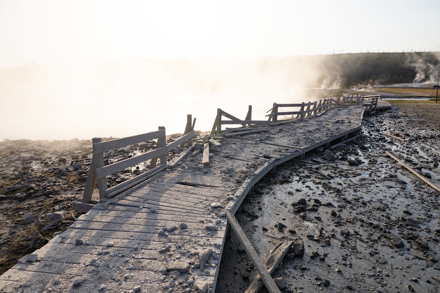 a damaged boardwalk covered in rock and debris