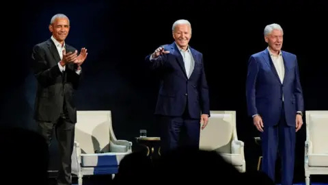 Reuters Presidents Obama, Biden and Clinton standing on stage