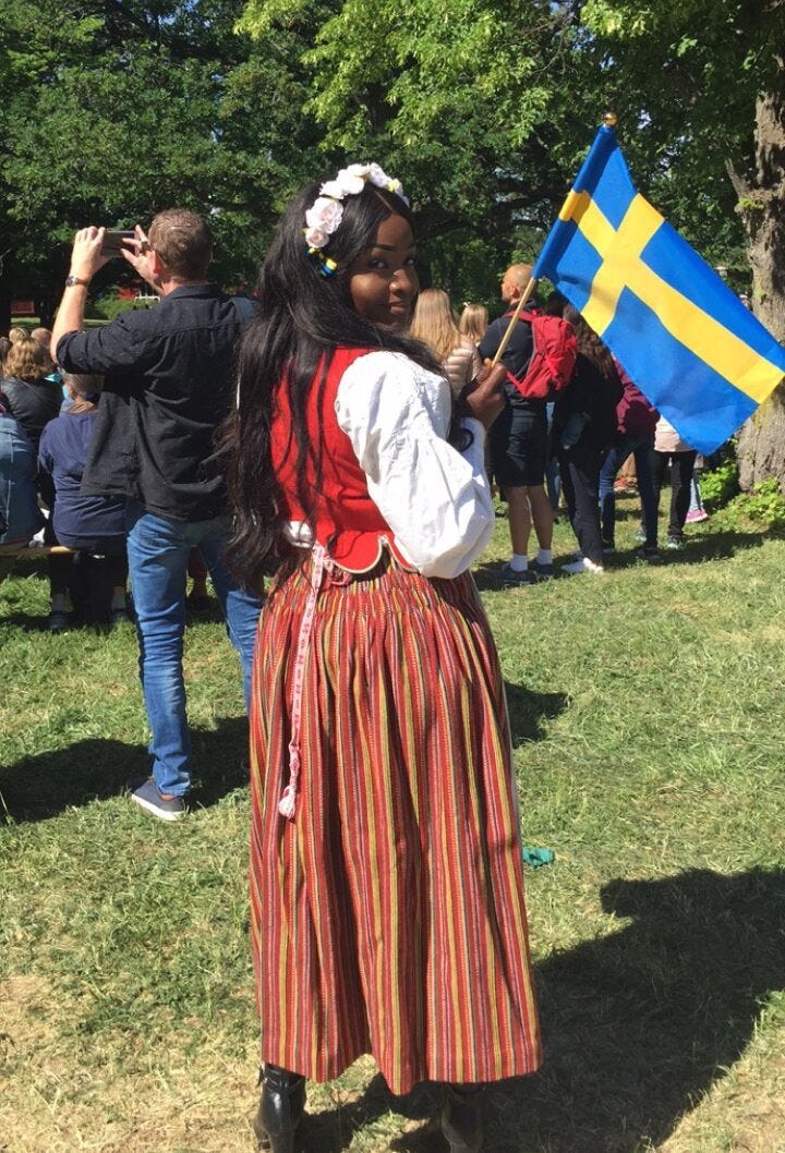 Lovette Jallow wearing traditional swedish clothing wavibg swedish flag Lovette Jallow wearing traditional swedish clothing wavibg swedish flag