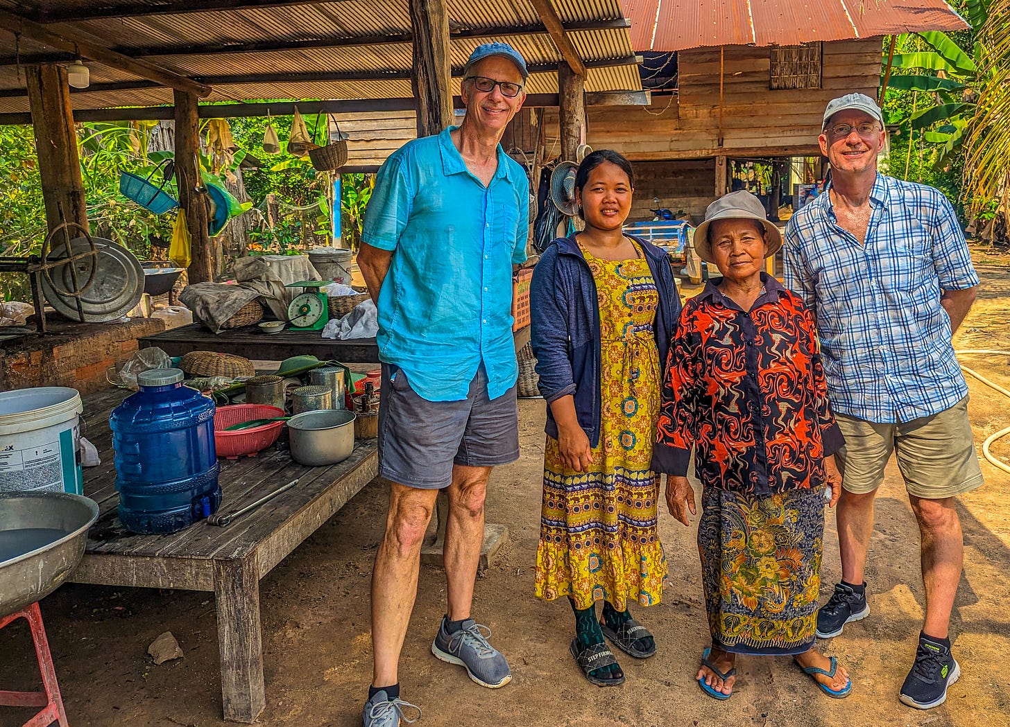 Brent and Michael posing with our hosts in their outdoor work area where the rice noodles are made. 