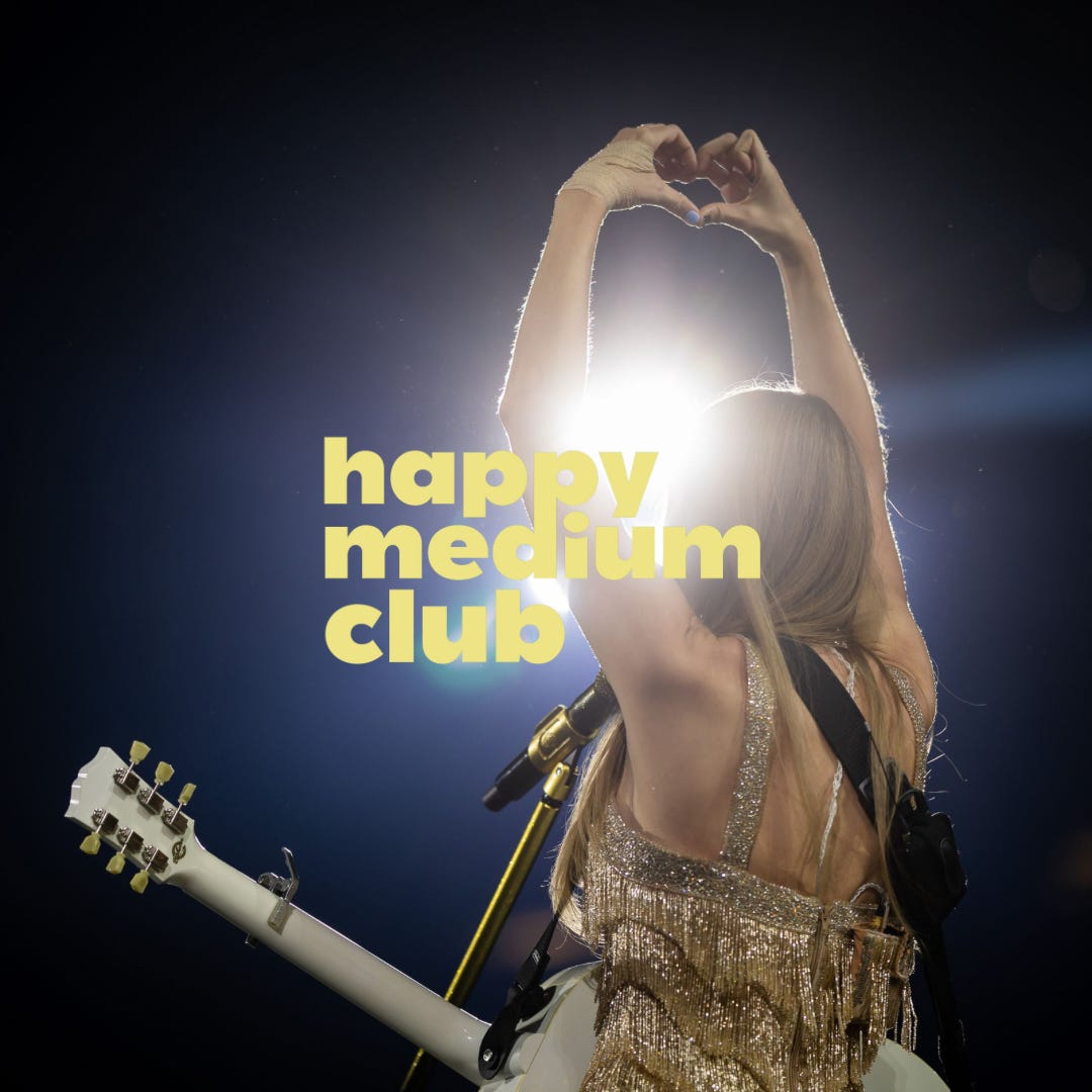 Taylor Swift holds up a heart sign at a concert. Text reads Happy Medium Club.