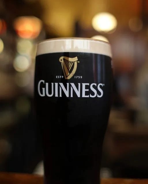 A freshly poured pint of Guinness with creamy head, on a rustic Irish pub counter.