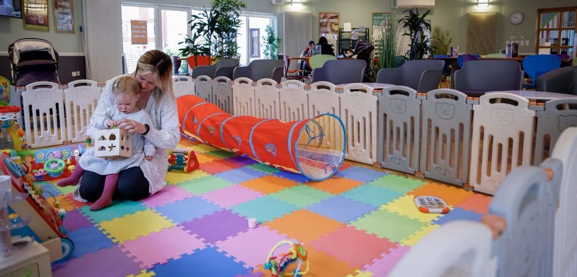 woman and toddler playing in a colourful play area