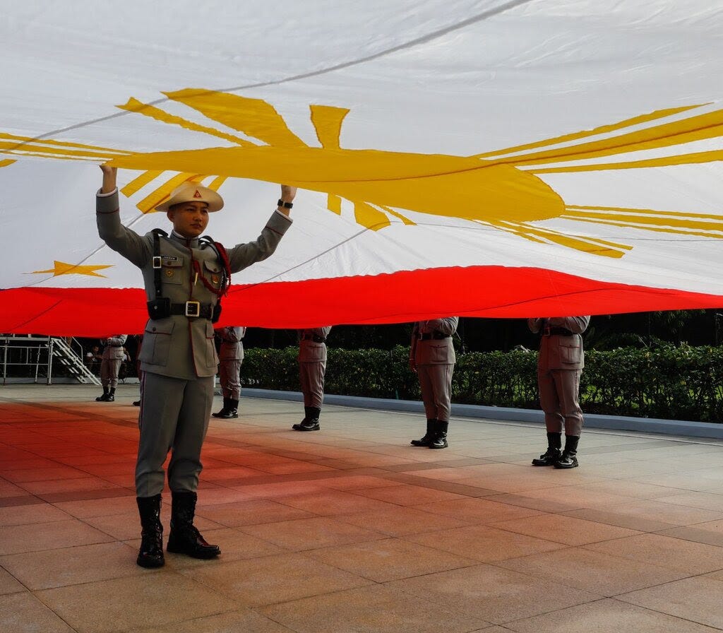 Soldiers hold a Philippine flag. 