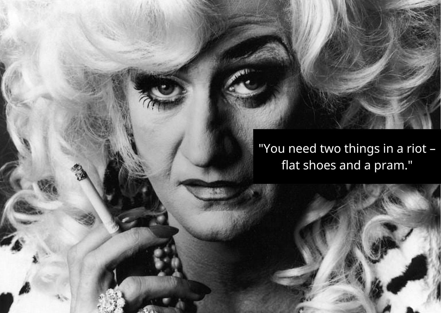 A black and white photo of Lily Savage. The text on it reads: "You need two things in a riot — flat shoes and a pram."