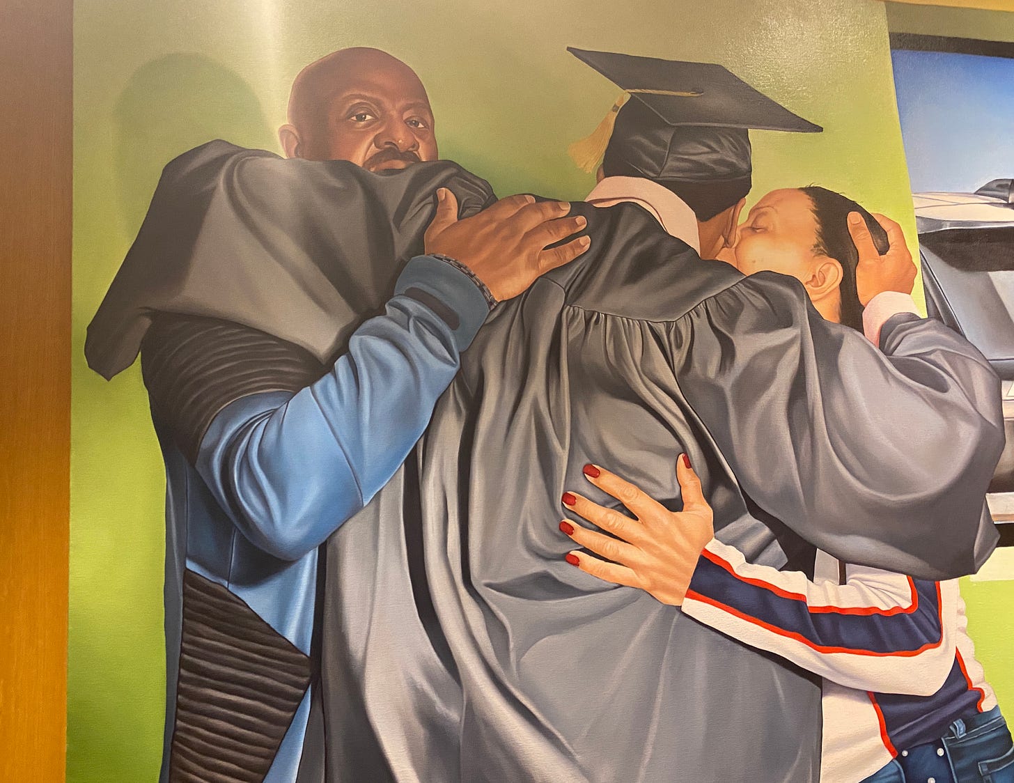 Painting of Black parents hugging their son in graduation gown