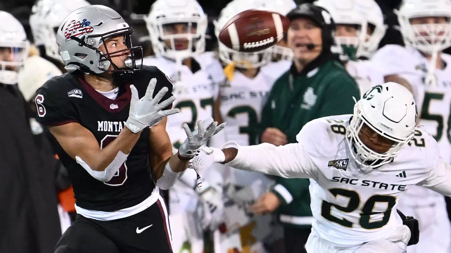 Football player preparing to catch an airborne ball as an opponent races to catch up with him, just yards away.