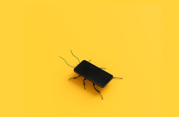 A black cockroach with a smartphone for a body crawls on a yellow surface.