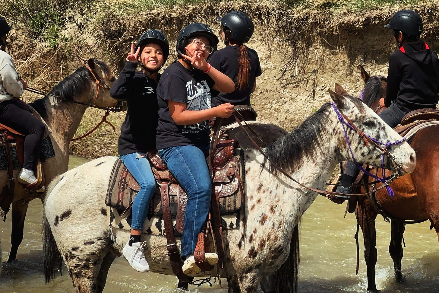 Sage kids riding the river next to the arena.