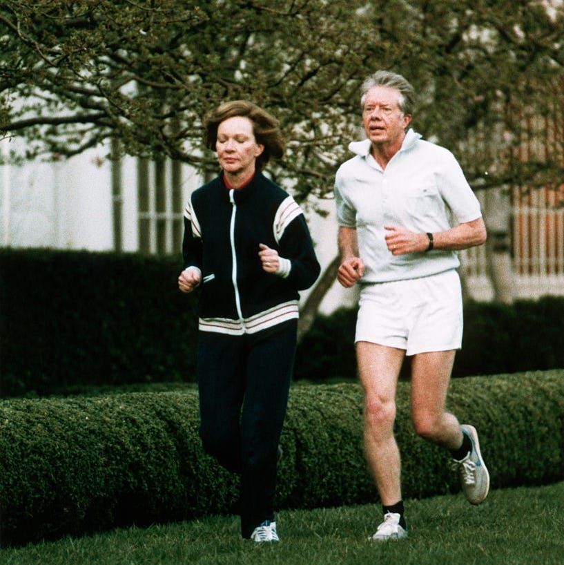 Jimmy and Rosalynn Carter running along the lawn of the White House in athletic clothing.