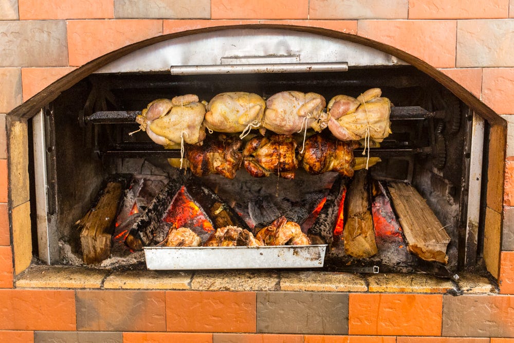 Chicken roasted over a wood fire at a pollería, a restaurant specializing in Pollo a la Brasa