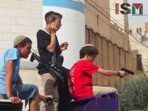 Settler children. One drinking wine, one holstering a machine gun and another aiming a pistol at onlookers 