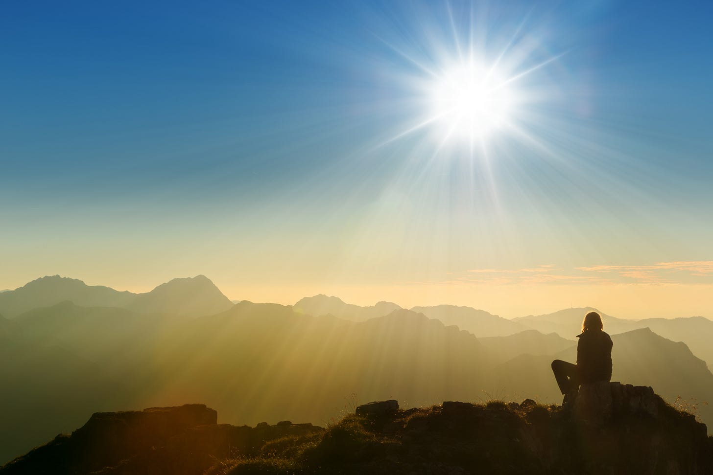 Photo of woman alone on a mountain top.