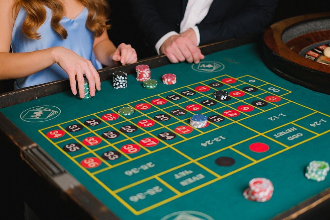 Free Captivating scene of a casino roulette table with gamblers placing their bets. Stock Photo