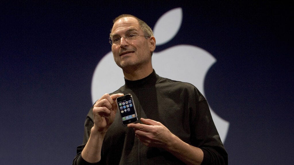 Steve Jobs holds up the new iPhone that was introduced at Macworld