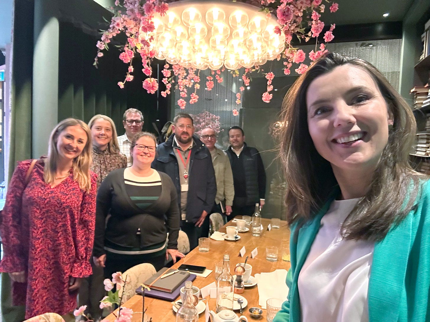 Smiling people standing next to a fancy breakfast table