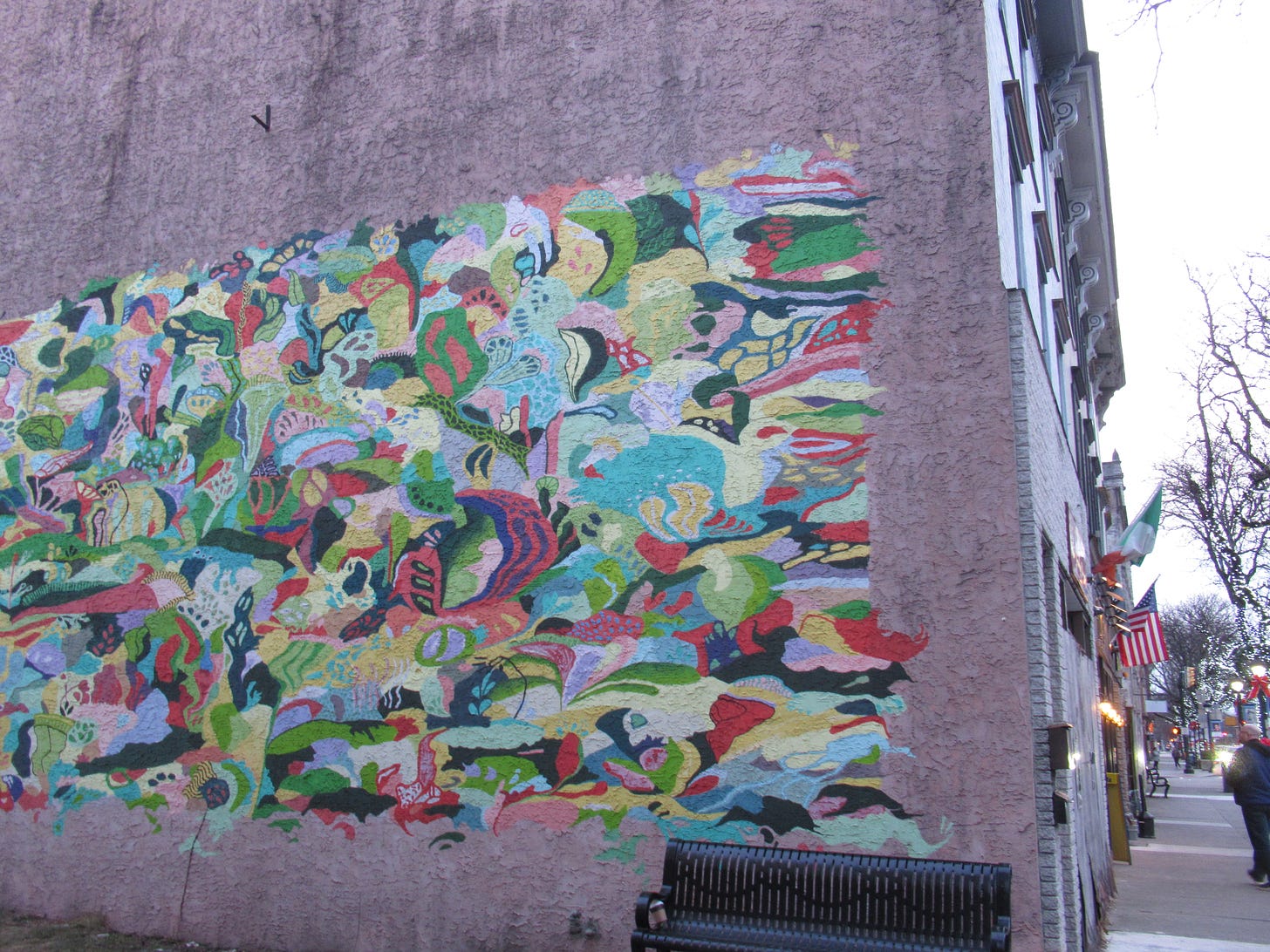 A colorful abstract art street mural on the side of a building in the old downtown of a northeaster Pennsylvania town