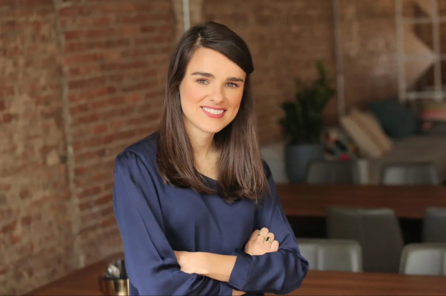 Headshot of Christina Cacioppo in a blue shirt with her arms crossed