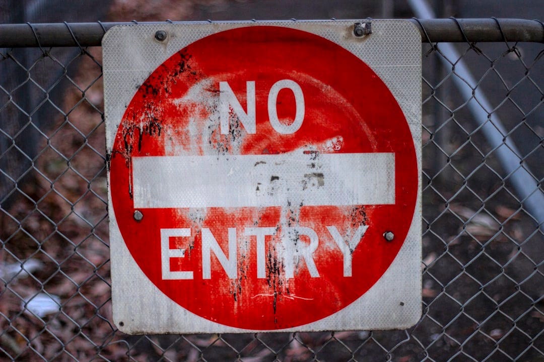 a no entry sign on a chain link fence