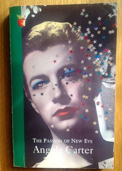A paperback edition of The Passion of New Eve with a vintage man's face colourised with makeup, covered in glitter stars