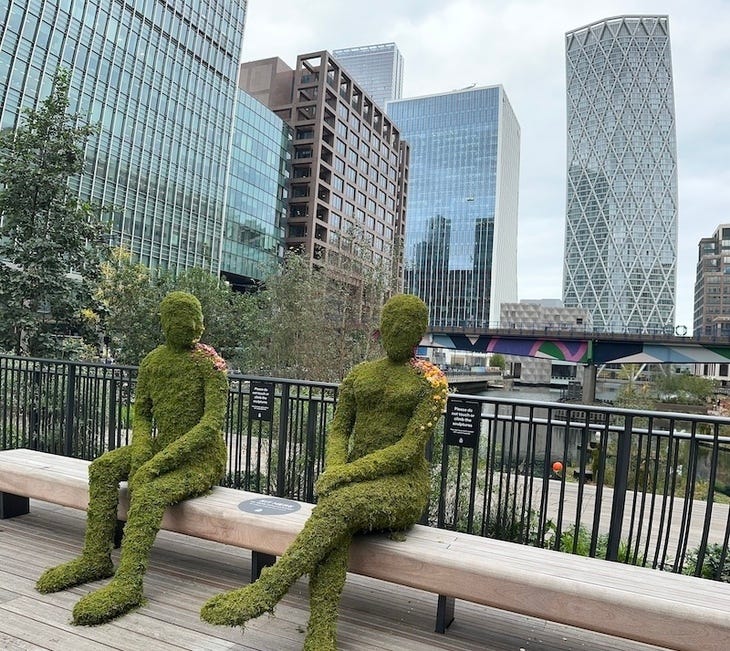 Two green mossy figures on a bench