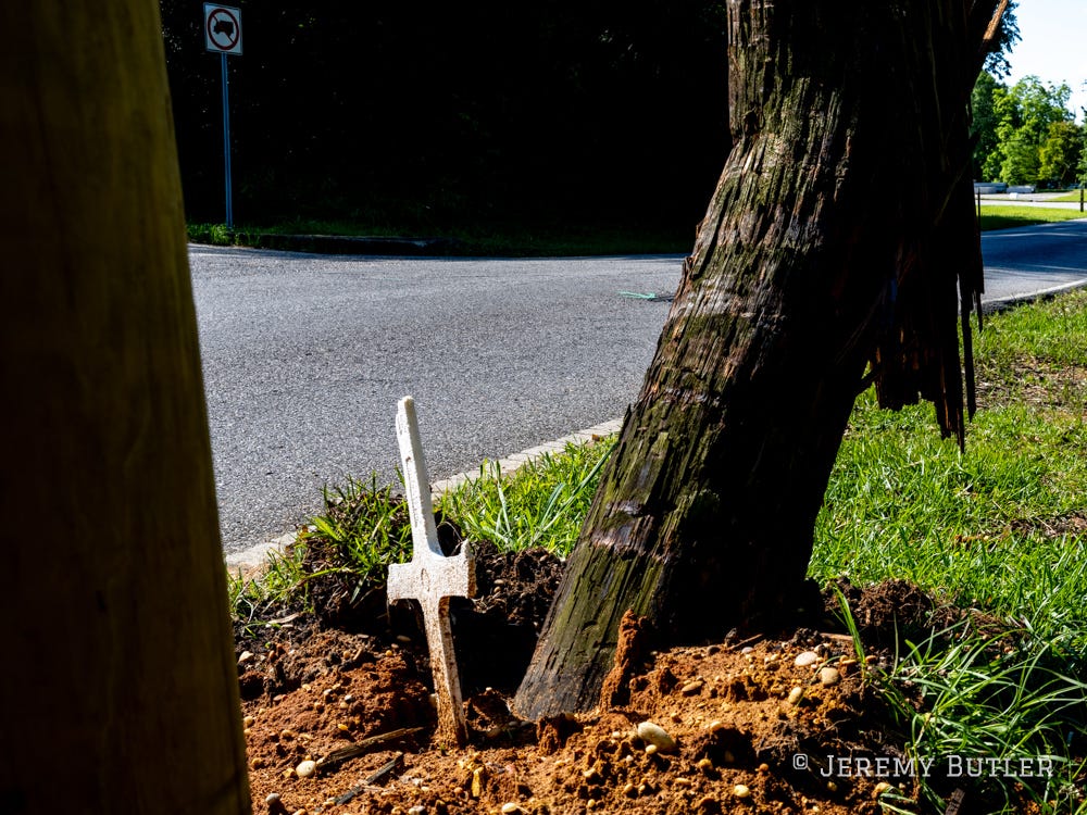 A Styrofoam cross marks the location of a traffic fatality
