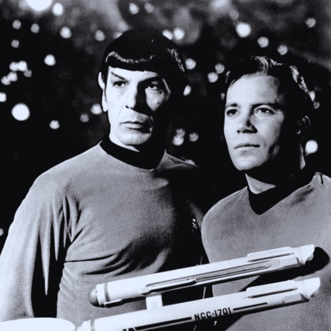 Captain Kirk and Spock from the original Star Trek series look into the distance. A small model of the Starship Enterprise floats in front of them. 