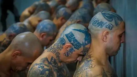 Reuters Gang members wait to be taken to their cells after 2000 gang members were transferred to the Terrorism Confinement Center