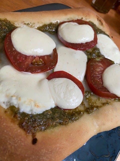 homemade pizza with sliced tomatoes and mozzarella