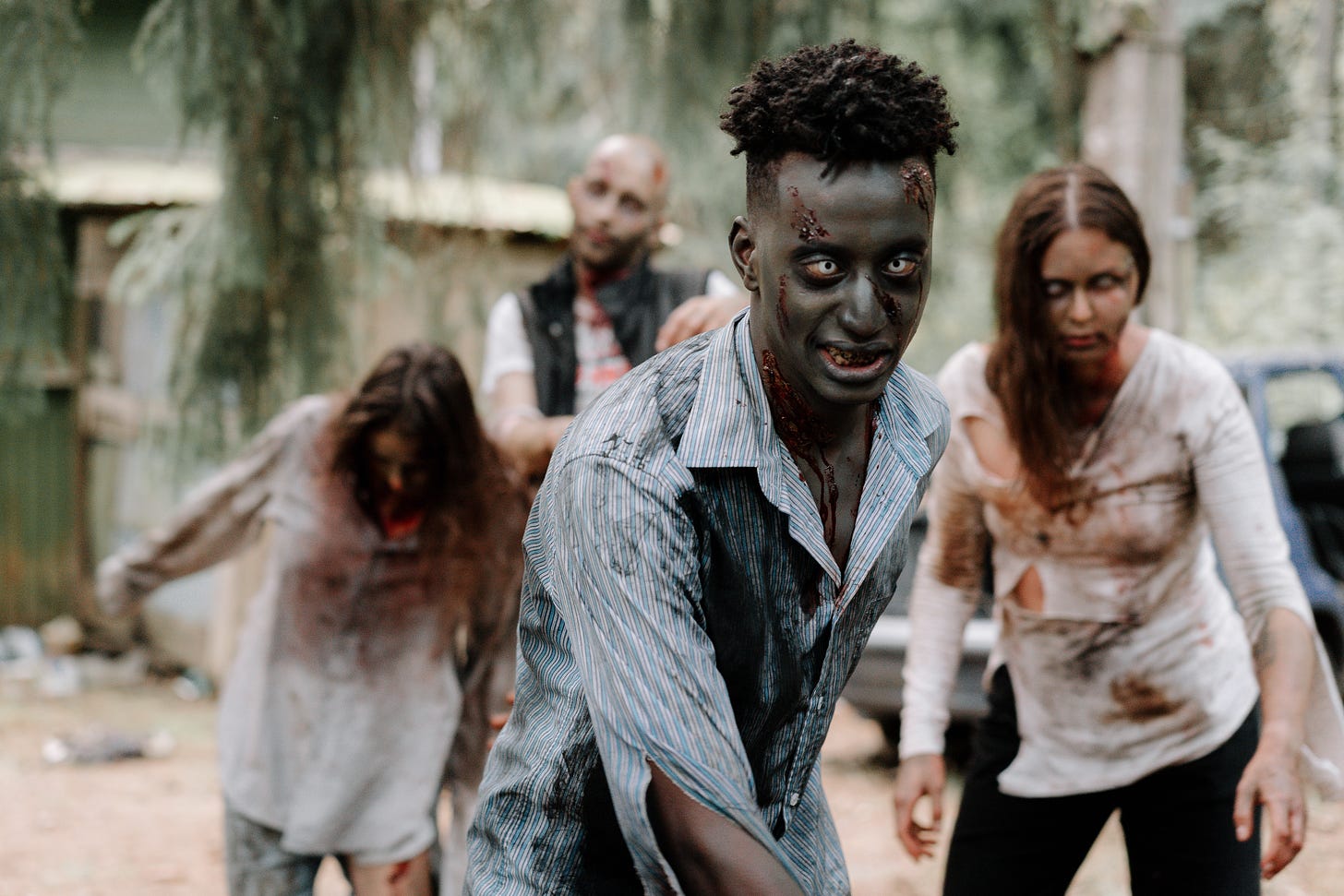 A photograph of a group of zombies lunging toward the camera.