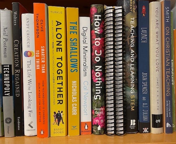 Books on a shelf, with topics related to technology, STEM education, and Christian education