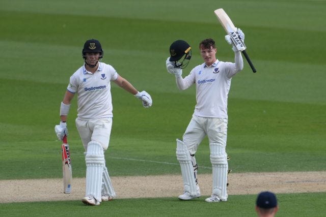 Tom Alsop celebrates reaching his century with batting partner Ali Orr