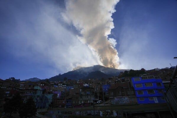 The sun rises during a forest fire on El Cable Hill in Bogota, Colombia, Thursday, Jan. 25, 2024. (AP Photo/Fernando Vergara)