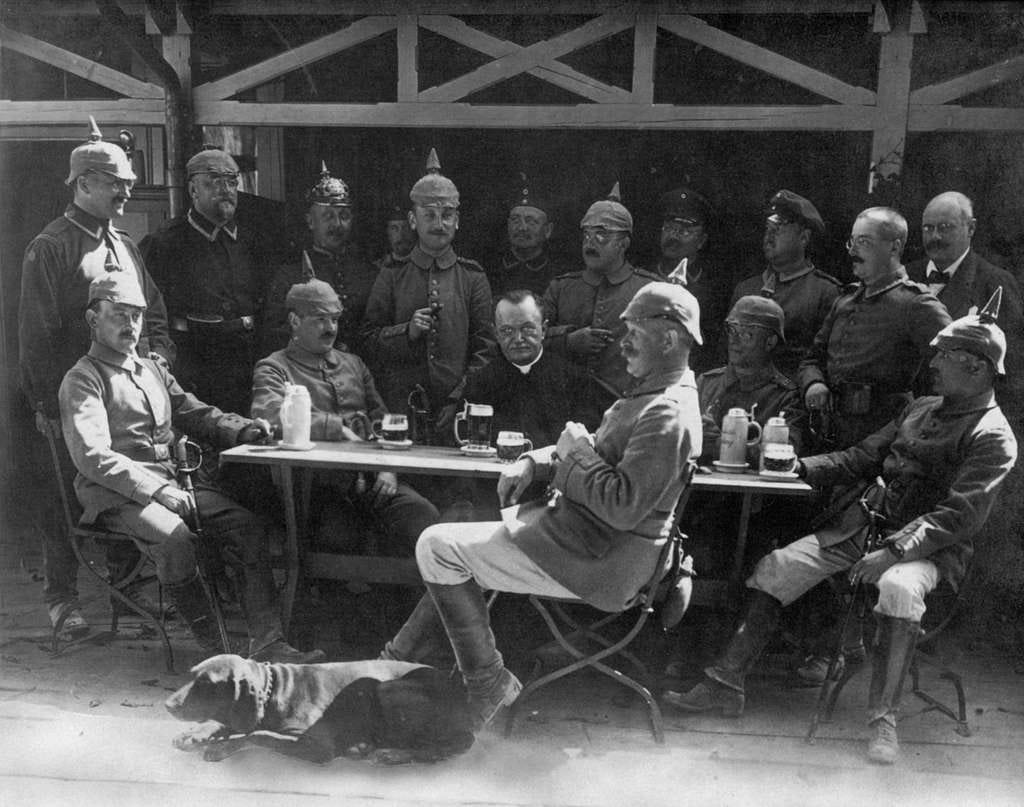 An awkwardly posed photo showing a group of German soldiers “enjoying” a few beers. One man and his dog sit on one side of a table facing, inexplicably, to the left, the other 16 site and stand on the other side and look in various directions. I’m reminded of the joke about Jesus booking the table for the Last Supper; “I’d like to book a table for 26 for me and my twelve disciples. Don’t you mean a table for 13. Oh no, we’re only going to sit on one side.” Note the scary looking chap in the centre who disapproves of my joke. 