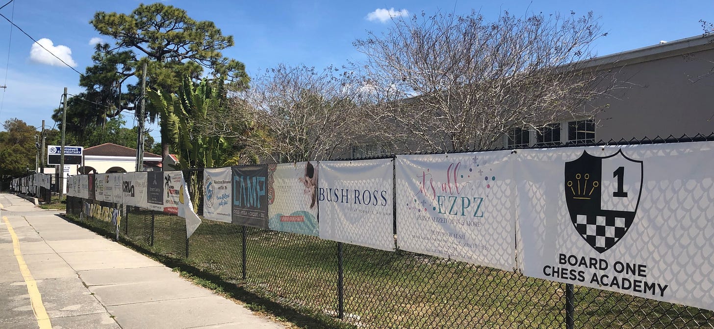 Advertisements lining school fence