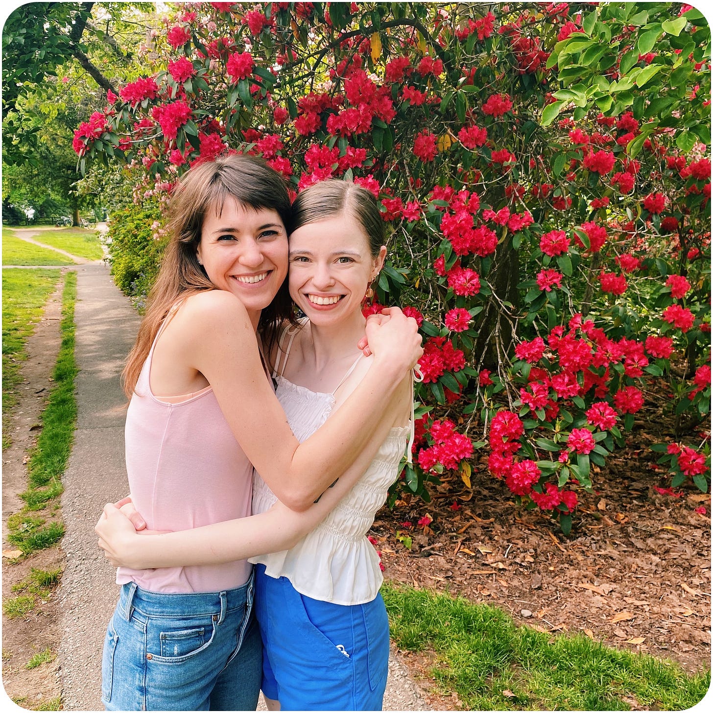 The illustrator and her pen pal embracing, a red rhododendron backdropping the two.