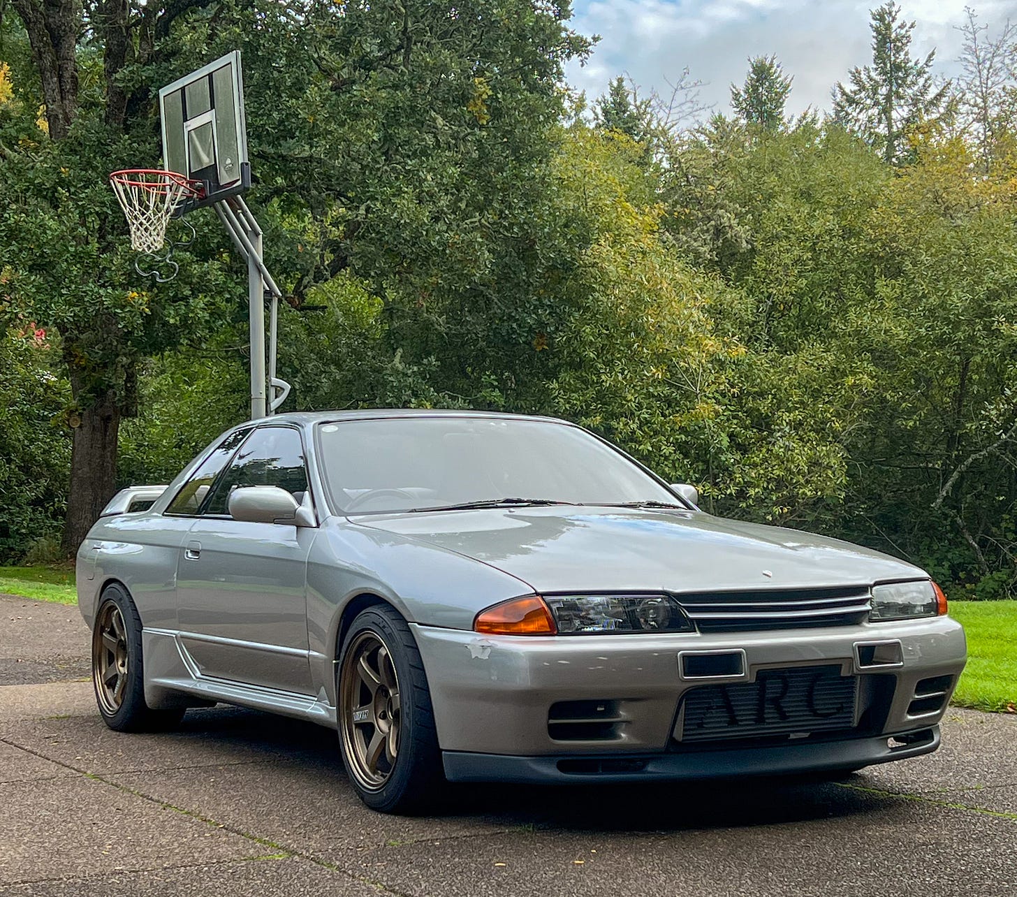 Front three-quarter view of a grey Nissan R32 Skyline GT-R once owned by MotoRex founder Hiro Nanahoshi.