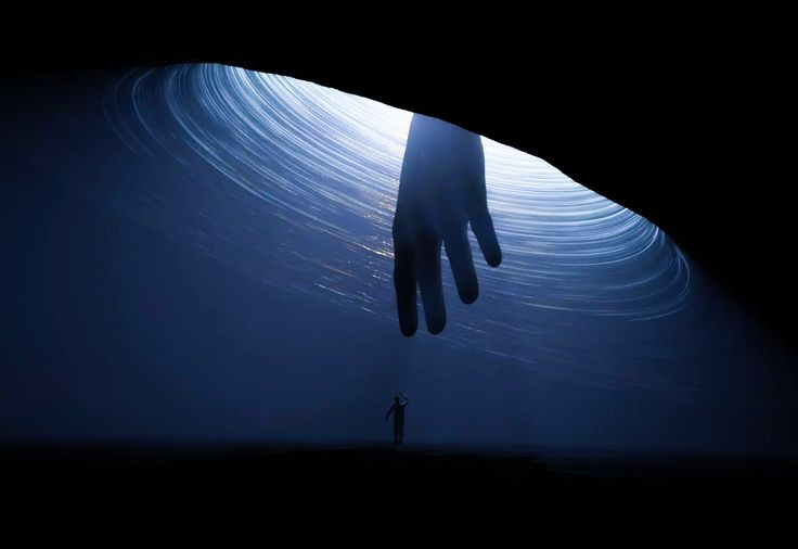 This may contain: a person standing in the middle of a tunnel with their hand up to the camera