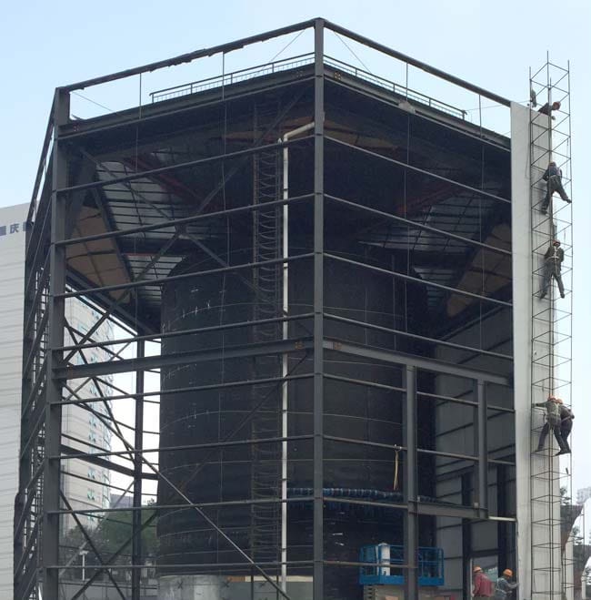 The cylinder entrance to Apple Jiefangbei under construction and covered in an octagonal structure.