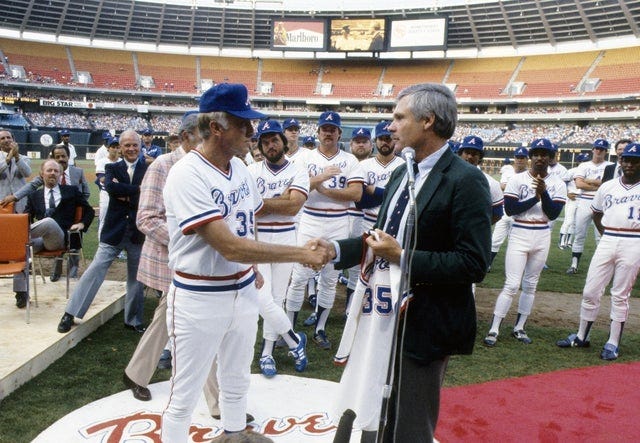 Ted Turner and Phil Niekro shake hands in Atlanta Fulton County Stadium