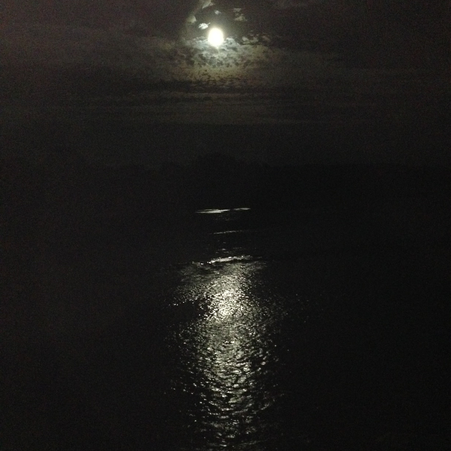 Image of dark night with some clouds, a bright moon casting light on a river below