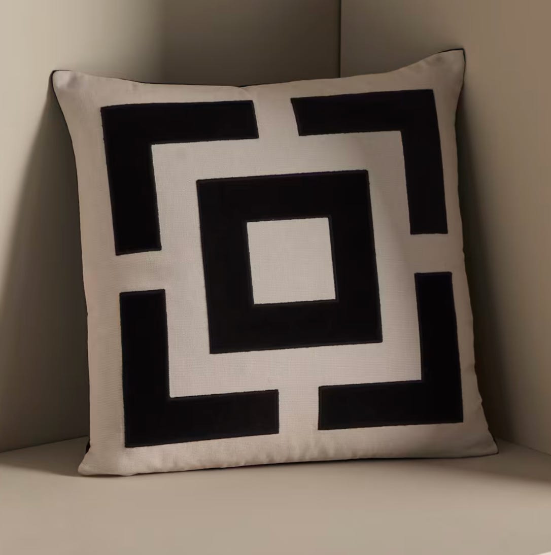 geometric patterned cushion applied as an appliqué panel in monochrome tones