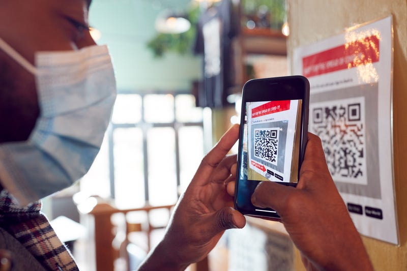 man in mask getting ready to scan potential dangerous QR code