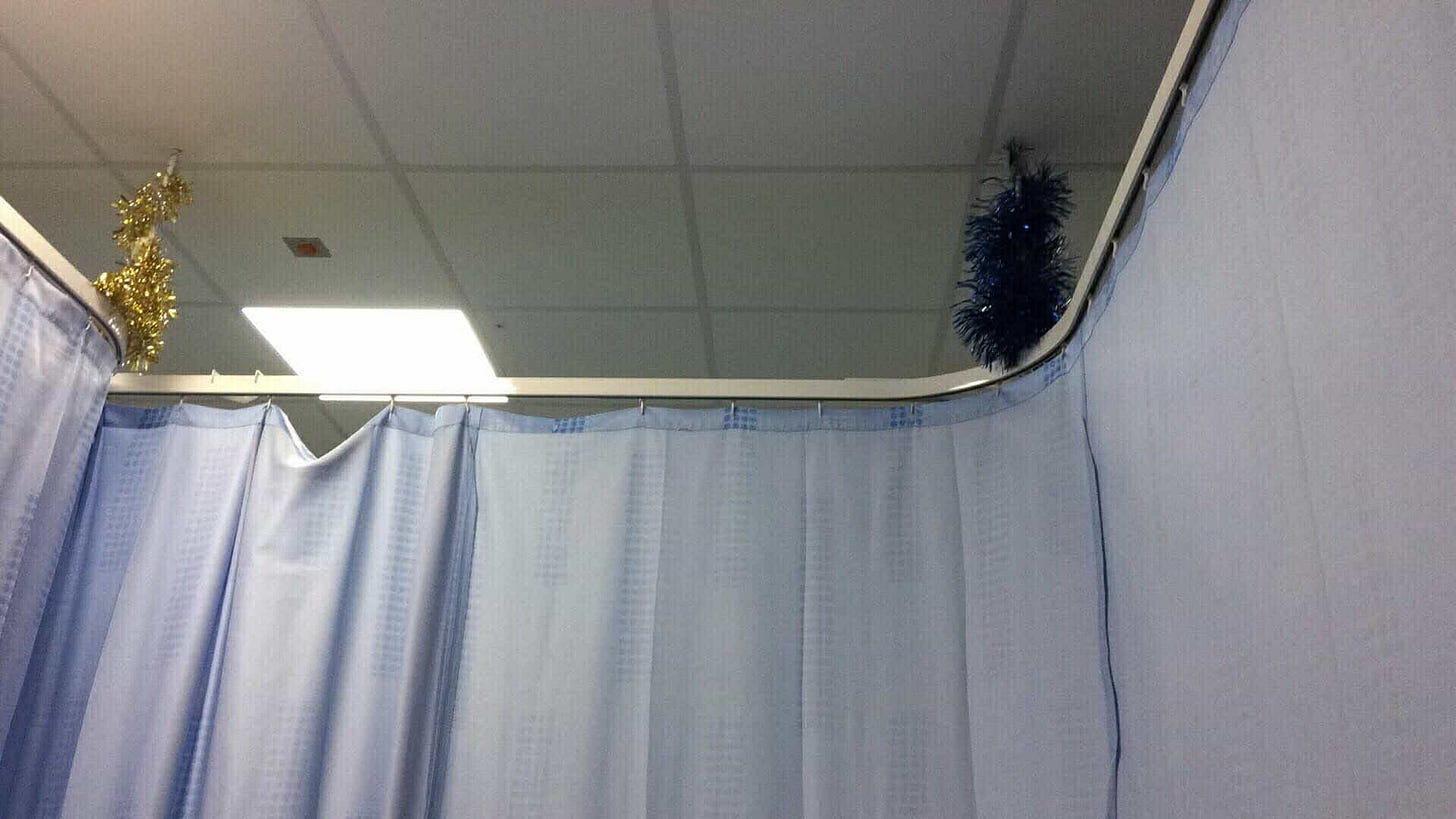 A picture of the hospital curtain light blue then the cieling and some tinsely wrapped around the curtain rods A picture of the hospital curtain light blue then the cieling and some tinsely wrapped around the curtain rods