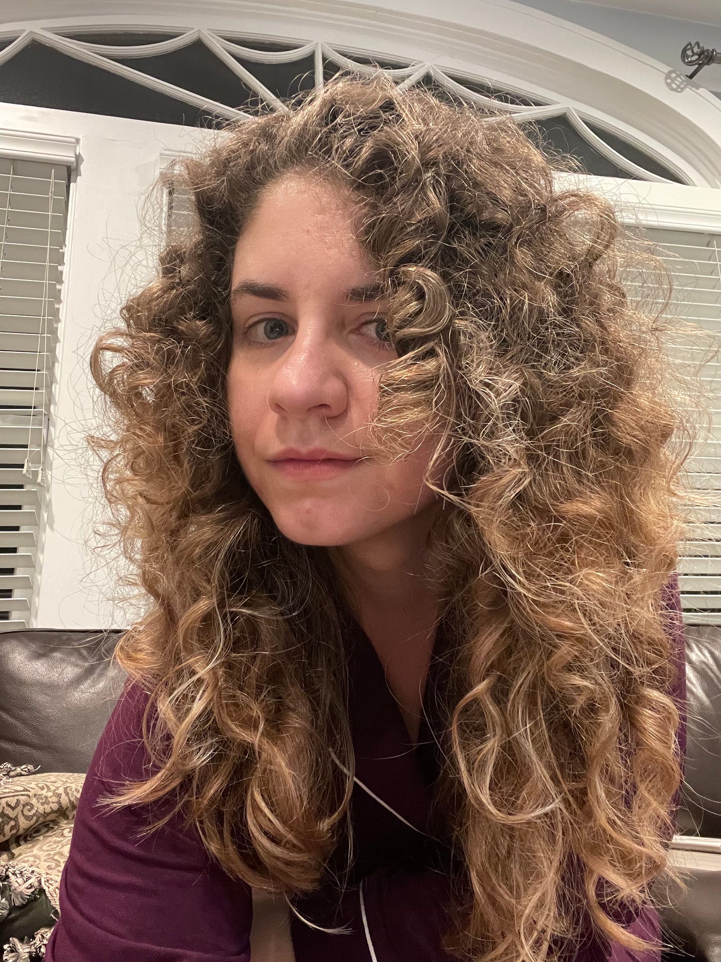 A white woman with blonde curly hair in maroon pjs