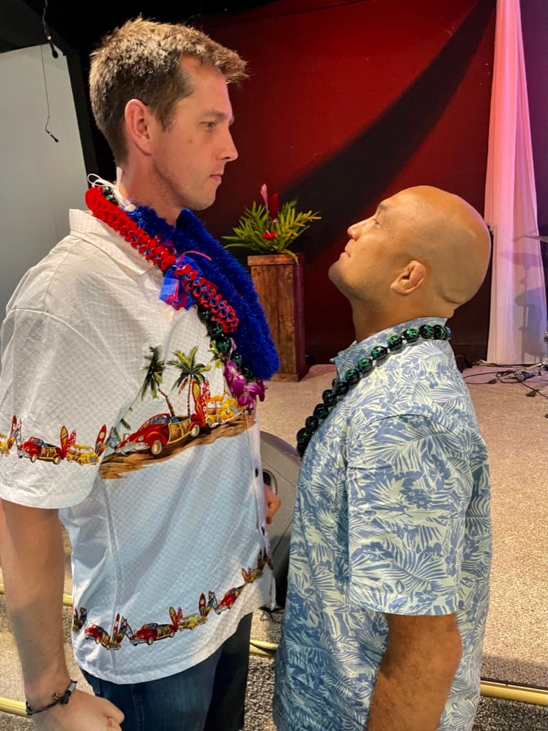 Two men wearing hawaiian shirts

Description automatically generated