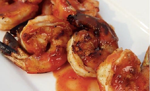 A plate of shrimp with sauce

Description automatically generated