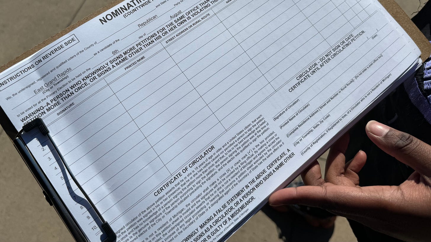 Clipboard with petitions held by a Black woman circulator